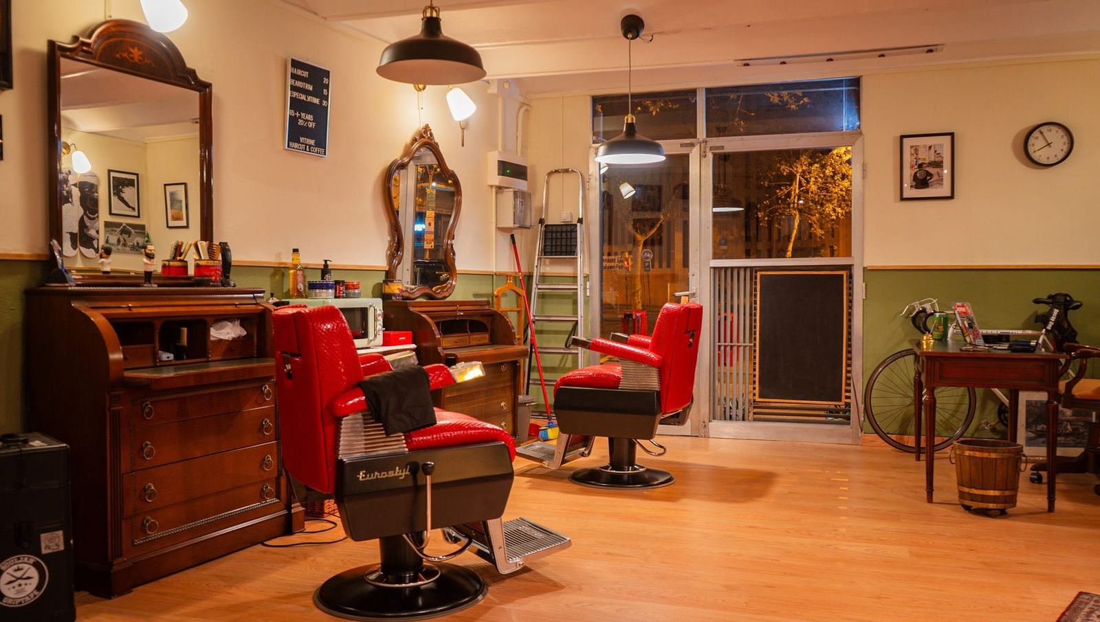 Sala principal de Vitrine con los dos sillones de barbero rojos, muebles de madera y espejos antiguos